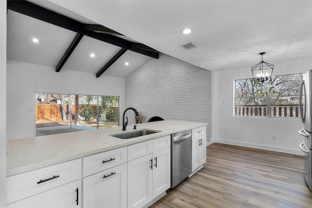 kitchen with sink, brick wall, appliances with stainless steel finishes, and light stone counters