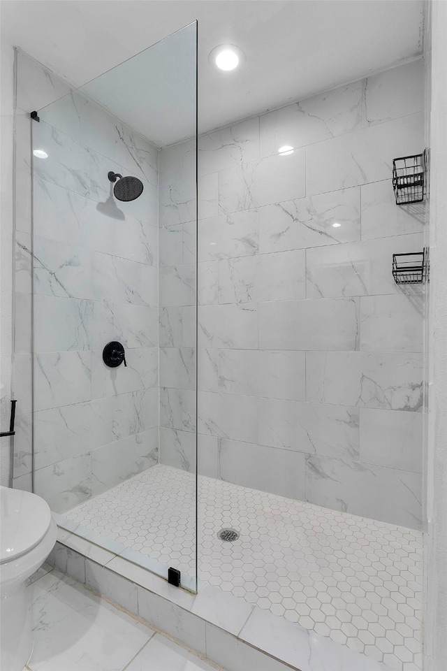 full bath with marble finish floor, tiled shower, and toilet