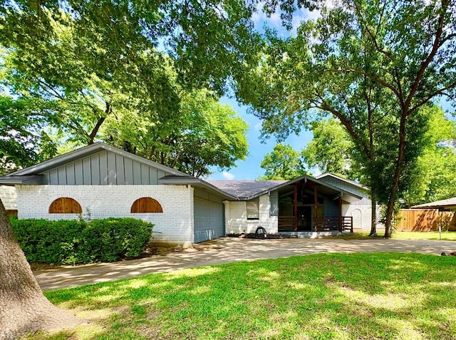 912 Glen Oaks Blvd, Dallas, TX 75232 - mid-century modern home featuring brick siding, an attached garage, concrete driveway, and board and batten siding