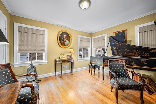 living area with a healthy amount of sunlight, ornamental molding, and light hardwood / wood-style flooring