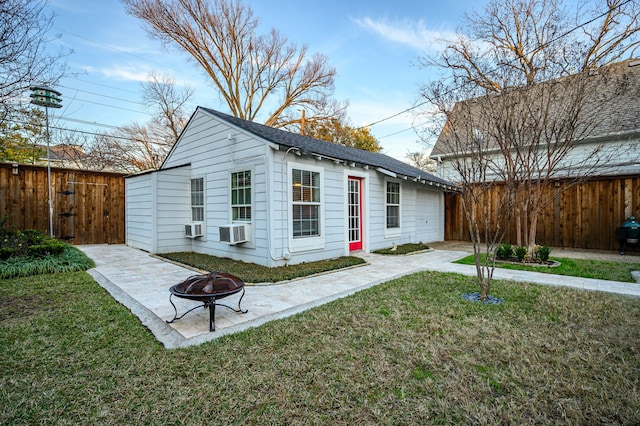 exterior space with an outbuilding, cooling unit, a fire pit, and a front yard