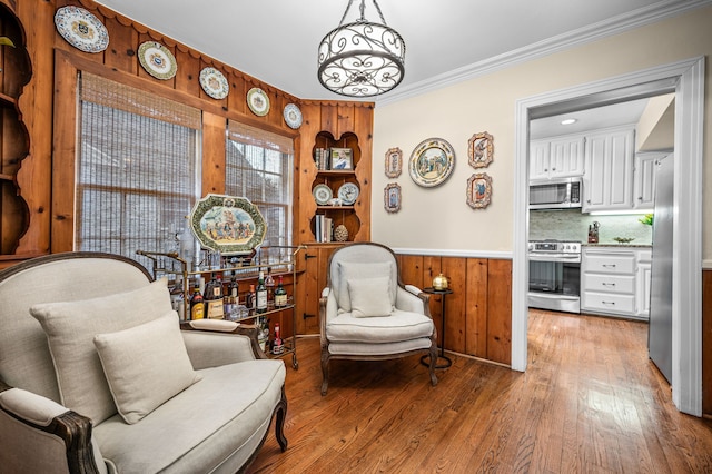 living area featuring crown molding and hardwood / wood-style floors