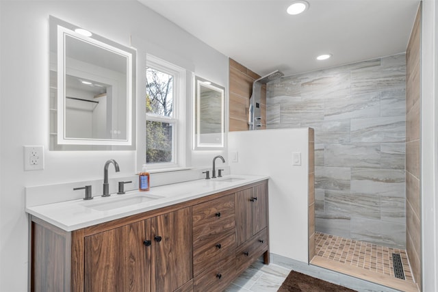 bathroom with vanity and a tile shower