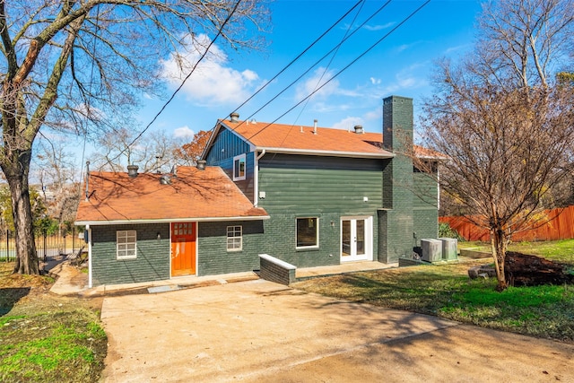 back of house featuring a lawn, a patio, and central air condition unit