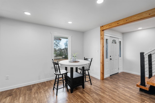 dining area with wood-type flooring and beam ceiling