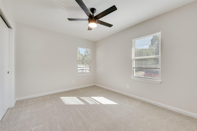 unfurnished room featuring ceiling fan and light colored carpet