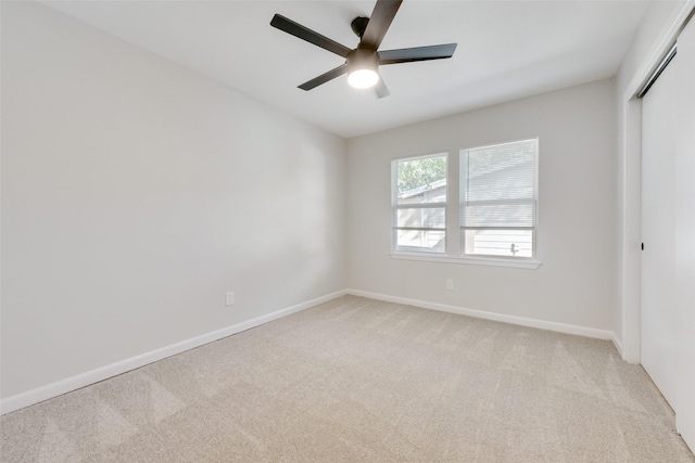 carpeted spare room featuring ceiling fan