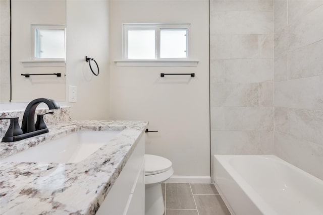 full bathroom featuring toilet, vanity, tiled shower / bath combo, and tile patterned flooring