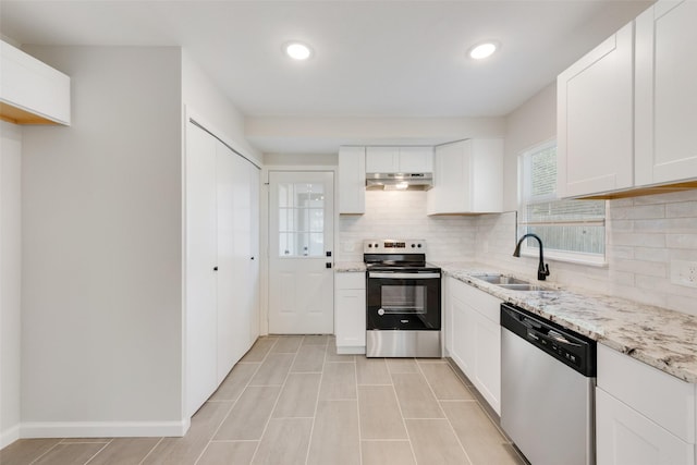 kitchen featuring tasteful backsplash, sink, light stone countertops, appliances with stainless steel finishes, and white cabinets