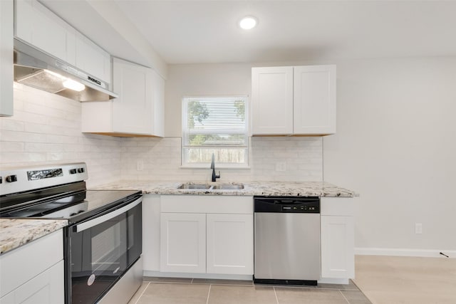 kitchen with stainless steel appliances, tasteful backsplash, light stone countertops, white cabinets, and sink