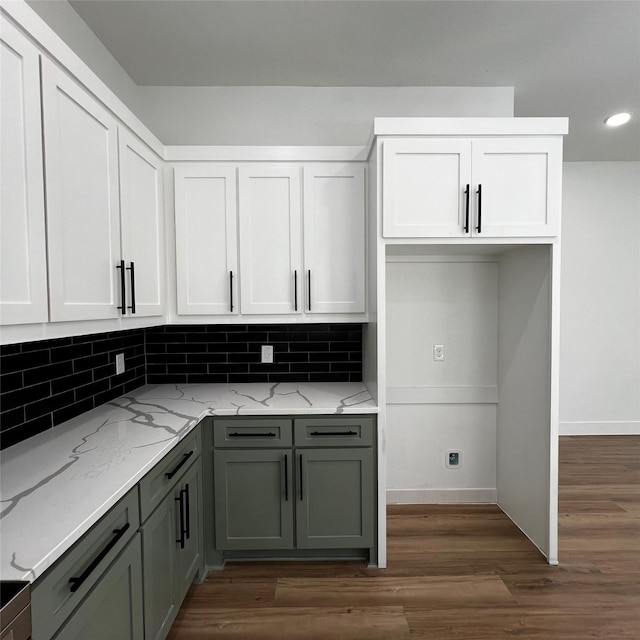 kitchen featuring backsplash, light stone countertops, and white cabinetry