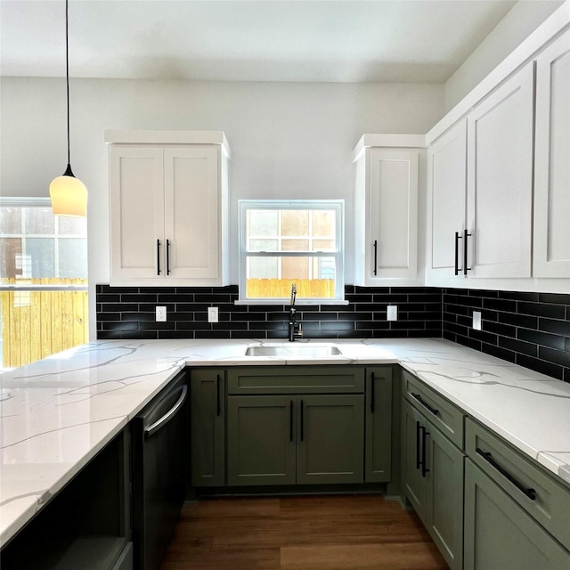 kitchen featuring pendant lighting, white cabinets, black dishwasher, sink, and light stone counters