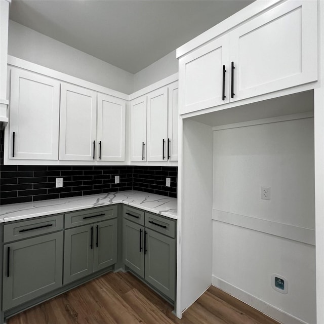 kitchen with dark wood-type flooring, decorative backsplash, white cabinets, and light stone counters