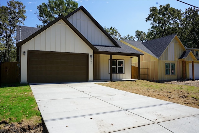 view of front facade featuring a front yard, a garage, and a porch