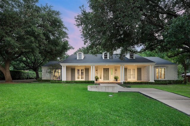 view of front of house with a yard, french doors, and a porch