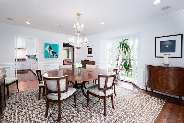 dining space featuring crown molding, hardwood / wood-style flooring, and a notable chandelier