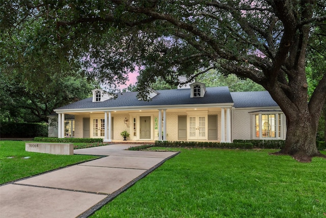 view of front of property with a lawn and french doors