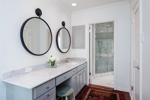 bathroom featuring ornamental molding, a shower with shower door, and vanity