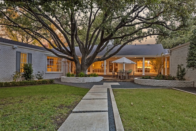 back of property featuring a lawn