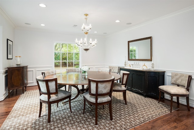 dining area with ornamental molding, hardwood / wood-style floors, and a notable chandelier