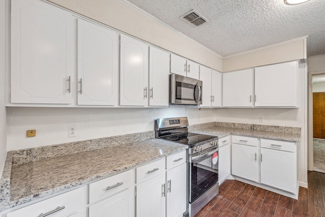 kitchen featuring white cabinetry, light stone counters, a textured ceiling, and appliances with stainless steel finishes