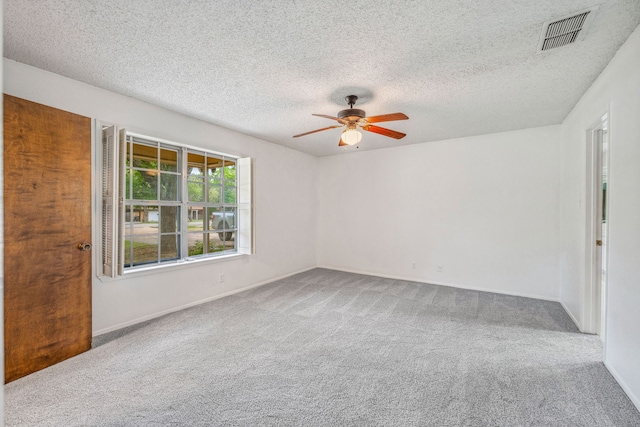 carpeted empty room featuring ceiling fan and a textured ceiling