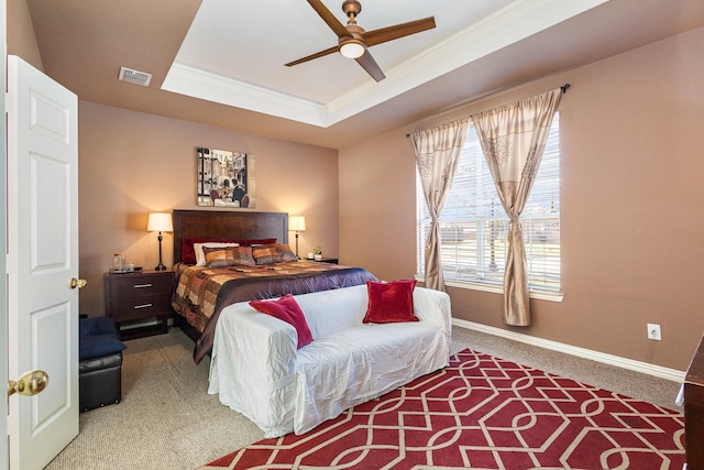 carpeted bedroom with ceiling fan, crown molding, and a raised ceiling