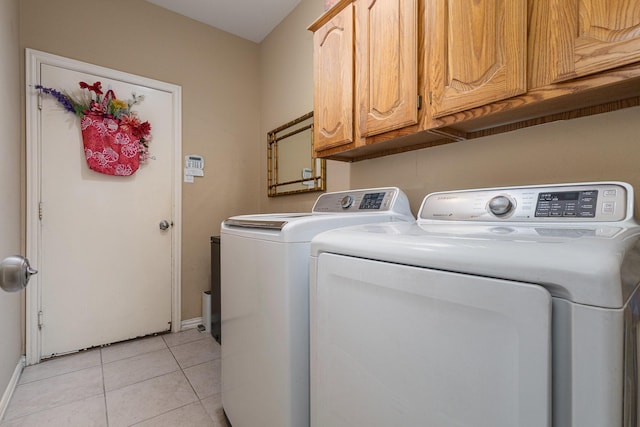 clothes washing area with cabinets, separate washer and dryer, and light tile patterned floors