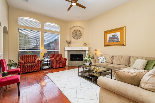 living room with ceiling fan, a fireplace, and hardwood / wood-style floors