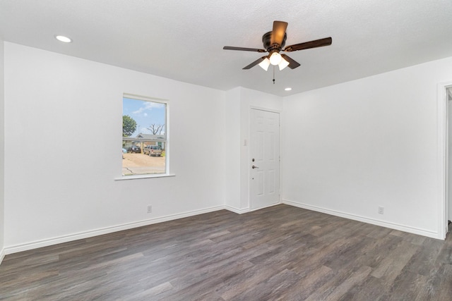 spare room featuring ceiling fan, dark hardwood / wood-style floors, and a textured ceiling