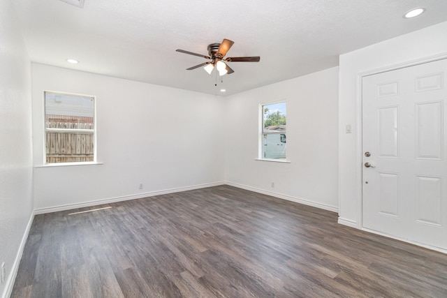 spare room featuring ceiling fan, dark wood-type flooring, and a textured ceiling