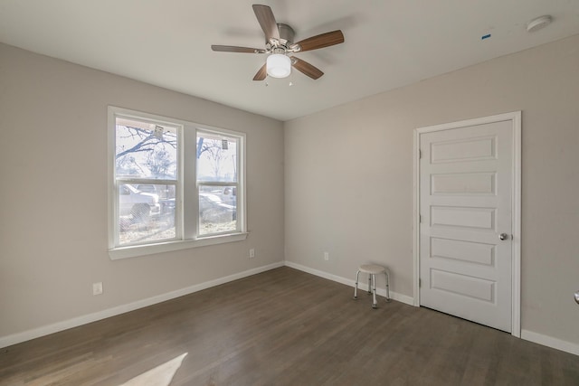 empty room with ceiling fan and dark hardwood / wood-style flooring