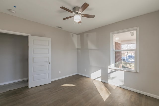 spare room featuring ceiling fan and dark hardwood / wood-style floors