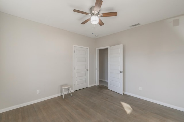 unfurnished room with ceiling fan and dark hardwood / wood-style floors