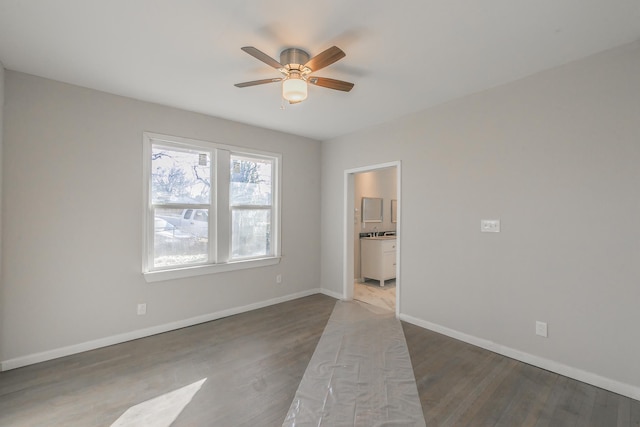 spare room featuring ceiling fan and dark wood-type flooring