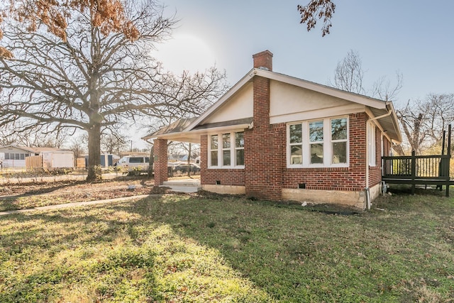 back of property featuring a wooden deck and a lawn