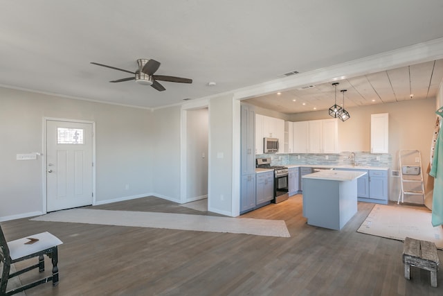 kitchen featuring tasteful backsplash, a center island, white cabinetry, hanging light fixtures, and stainless steel appliances