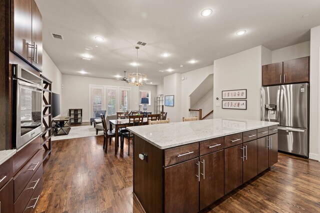 4211 Rawlins St Unit 733, Dallas, TX 75219 - kitchen featuring appliances with stainless steel finishes, a center island, recessed lighting, dark wood-style flooring, and a chandelier