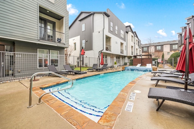 pool featuring a patio, fence, and a residential view
