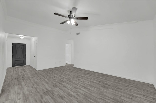 spare room featuring ceiling fan, ornamental molding, and wood-type flooring