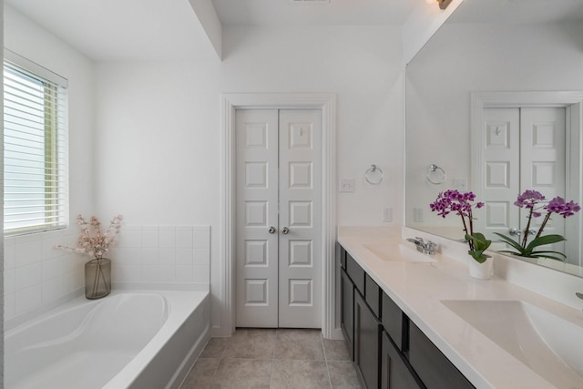 bathroom with vanity, a bath, and tile patterned flooring