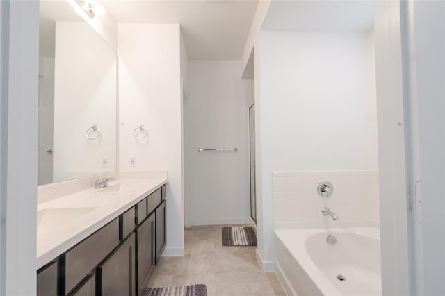 bathroom featuring tile patterned flooring, vanity, and a tub to relax in