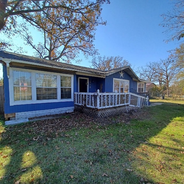 rear view of house featuring a lawn