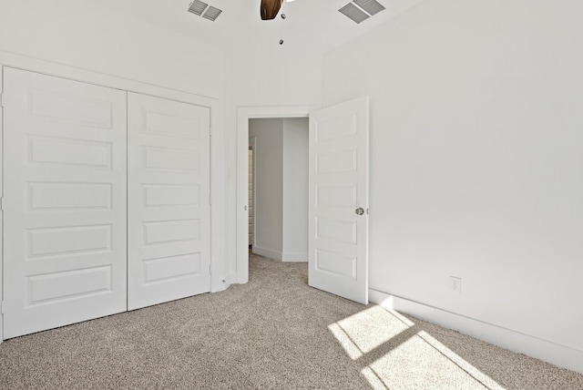 unfurnished bedroom featuring ceiling fan, a closet, and light carpet