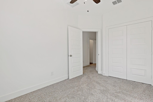 unfurnished bedroom featuring ceiling fan, a closet, and light colored carpet