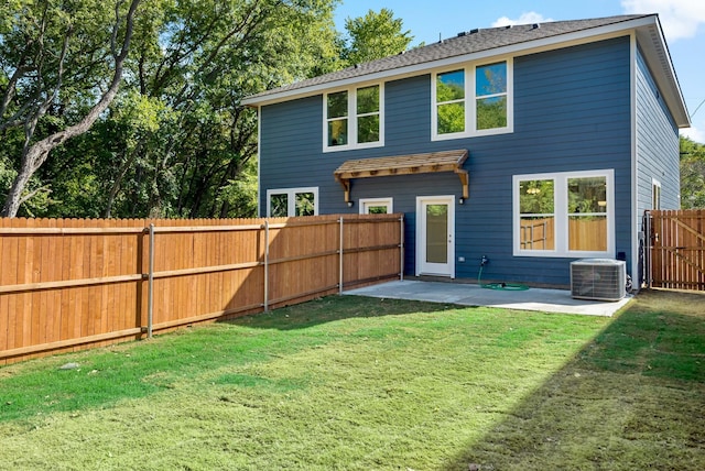 rear view of house with a patio area, a yard, and central AC