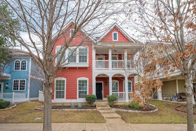 view of front of home with a front lawn, a balcony, and covered porch