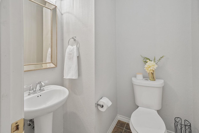 bathroom with toilet, tile patterned floors, and sink