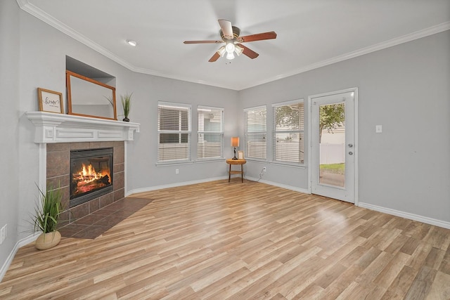 unfurnished living room featuring ceiling fan, light hardwood / wood-style flooring, ornamental molding, and a tiled fireplace