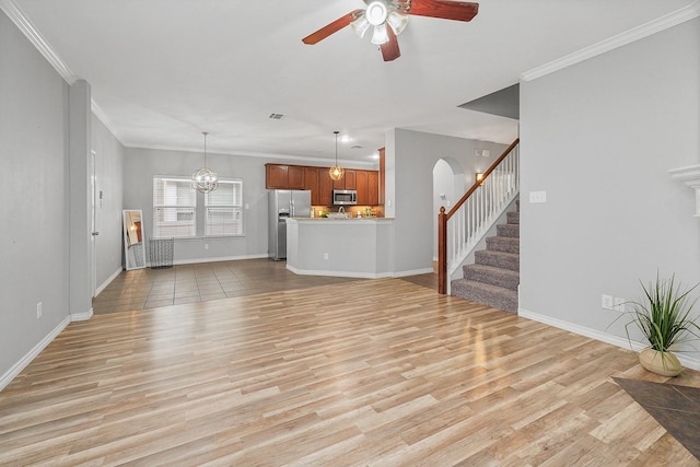 unfurnished living room featuring light wood-type flooring, ornamental molding, and ceiling fan with notable chandelier